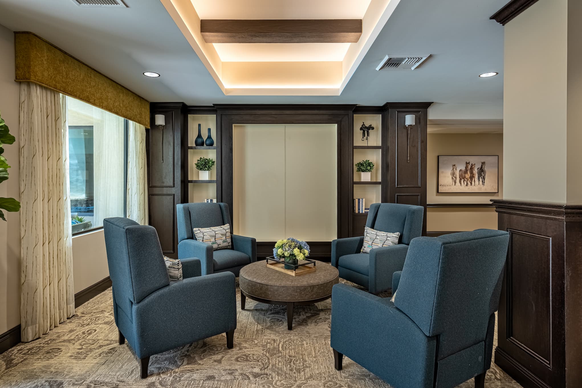Elegant living area with four armchairs around a large circle ottoman.