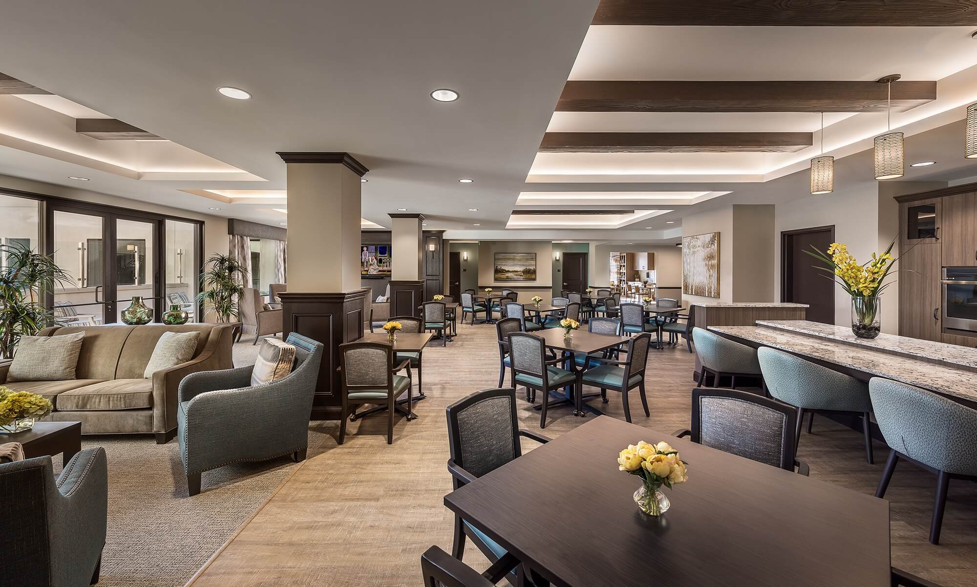 Large elegant communal space with ample seating, a living area, and a kitchen.